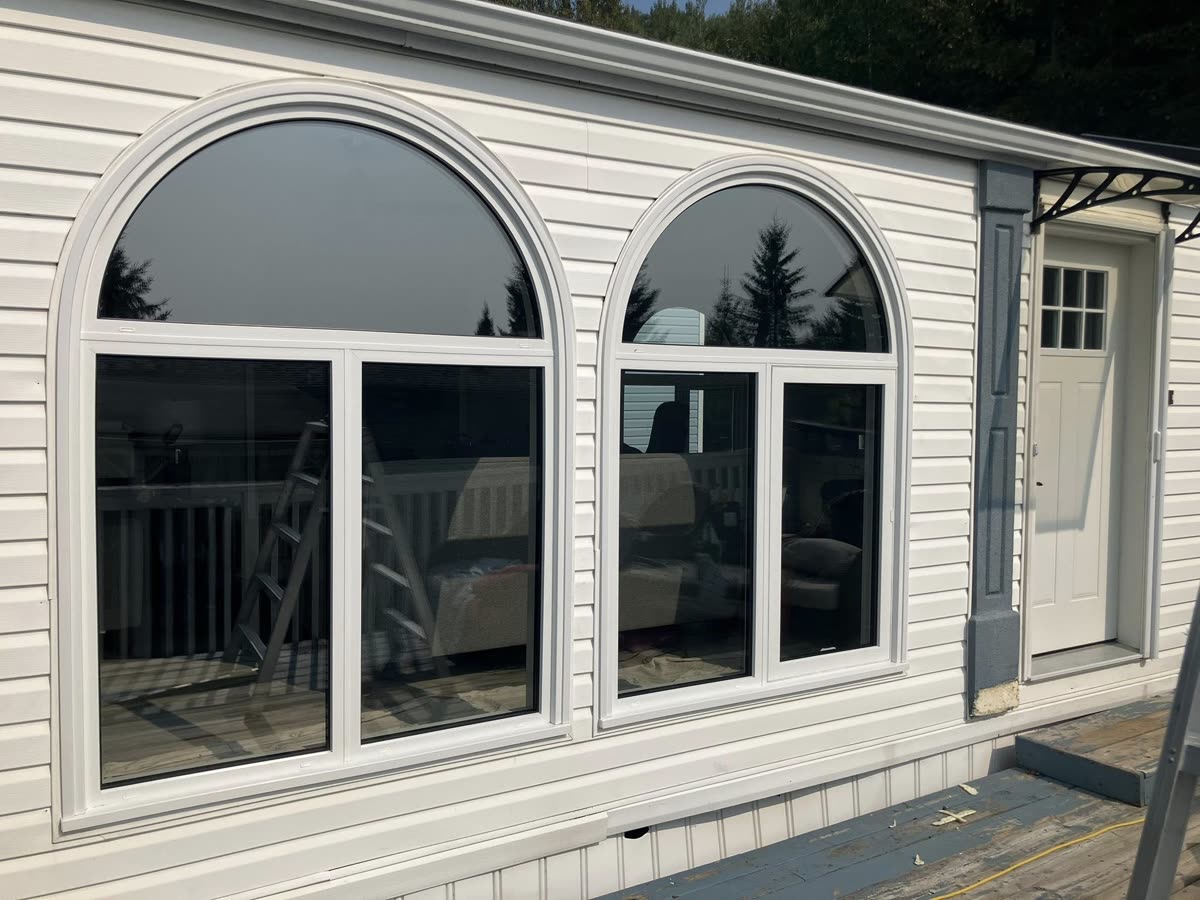 Two new arched picture windows installed by Lipstick Property Solutions on a Prince George home