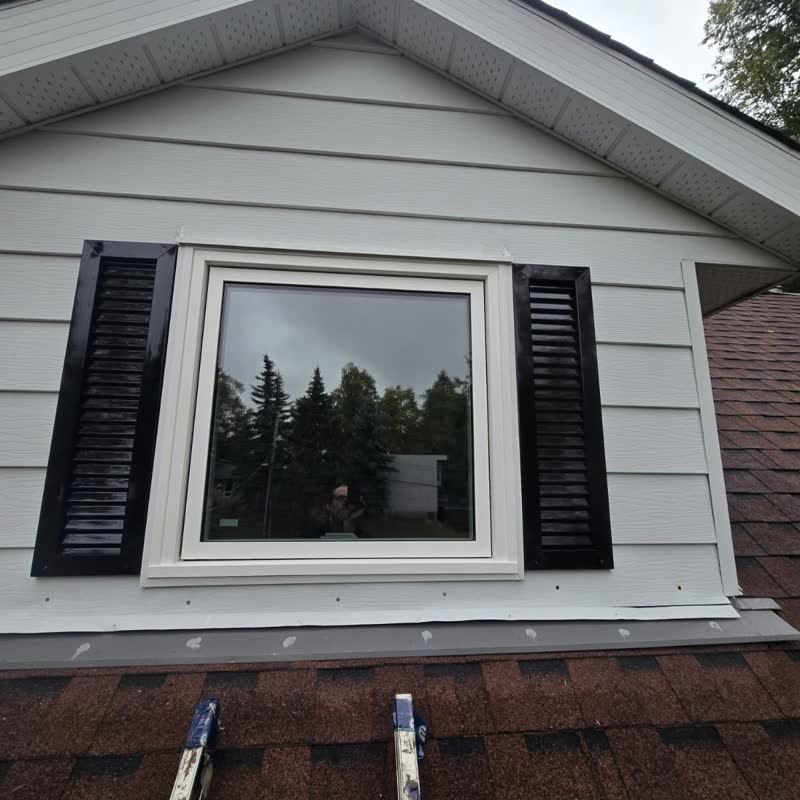 Square casement window framed by black shutters