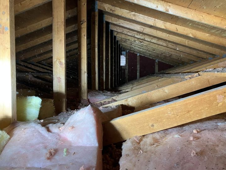 Before: Attic before the upgrade, with old pink batt insulation