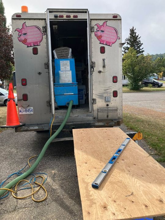 Insulation trailer with blower and hose at the curb