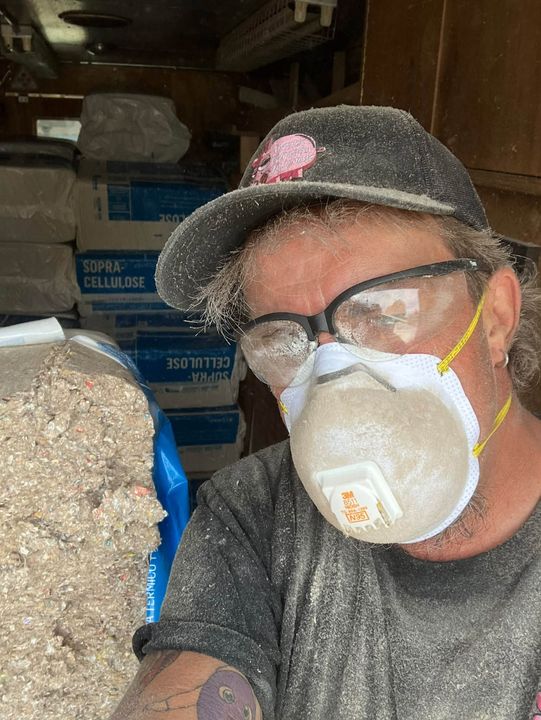 Insulation tech in a dust mask during the job