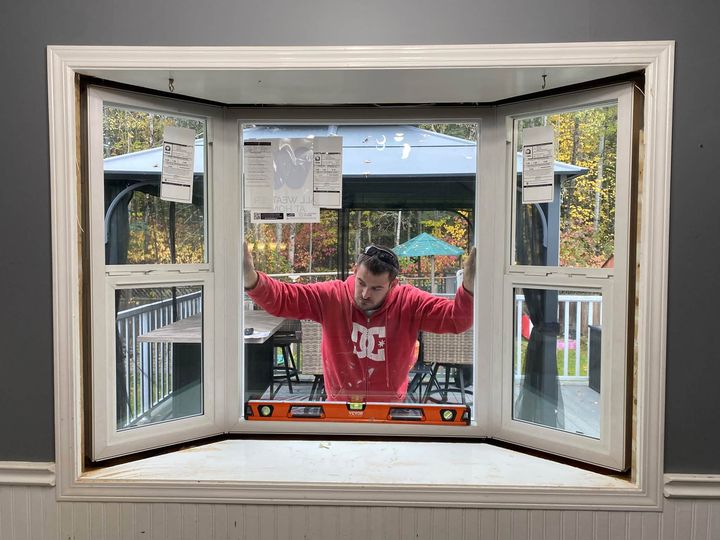 Installer leveling the new bay window from inside the room