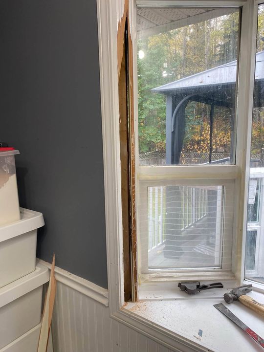 Side of the new bay window being fitted from inside