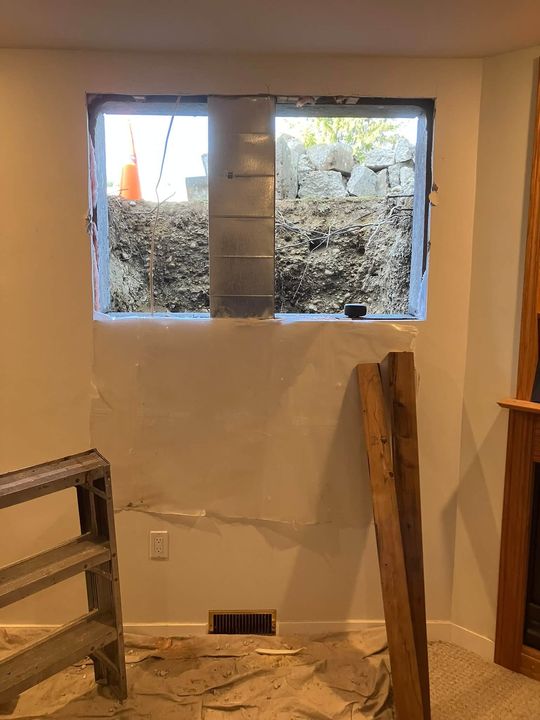 New basement window framed into the enlarged opening, inside