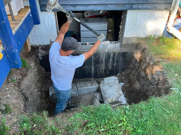 Worker breaking out the cut concrete in the excavation