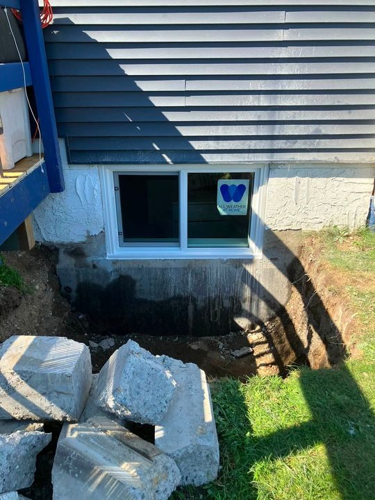 After: New egress window from outside with cut concrete on the lawn