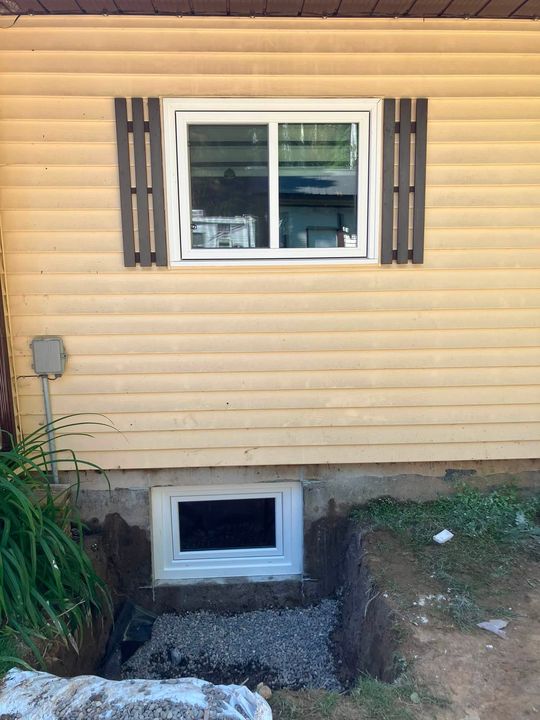 Finished egress window under the shuttered main-floor window