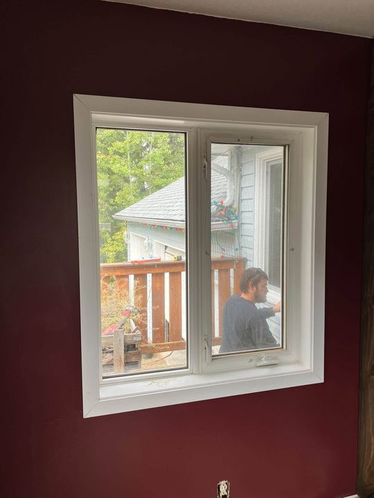 New window on a red wall, installer working outside