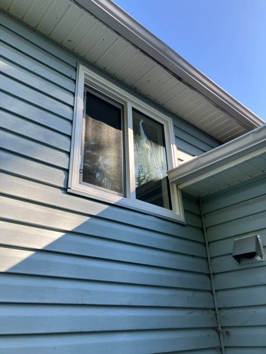 New window under the eaves on light-blue siding