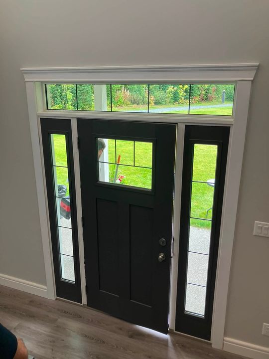 Reinstalled black entry door with sidelites and transom, inside