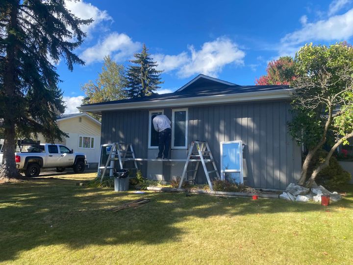 Crew working on the front windows of a grey bungalow