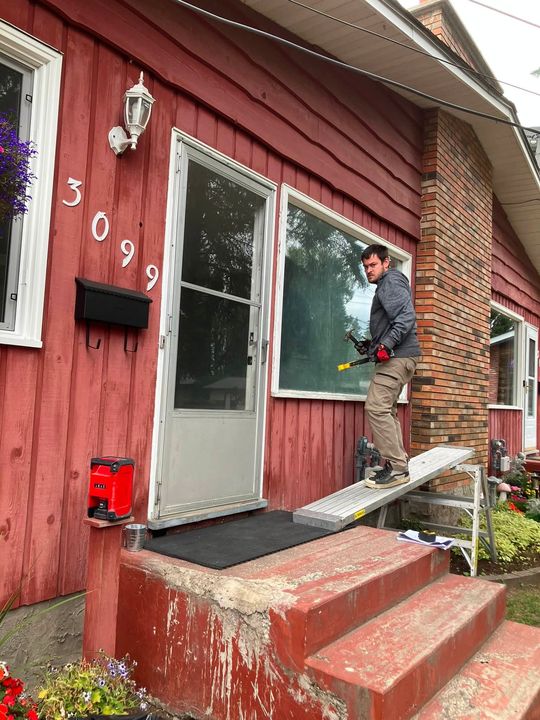 Installer fitting the new living room window from outside