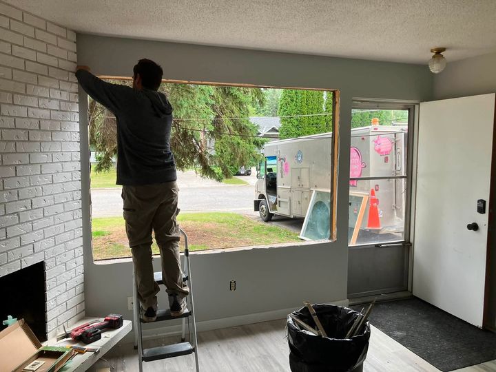 Installer on a ladder fitting the window from inside