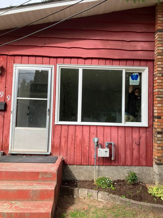 After: Finished living room window on a red-sided house