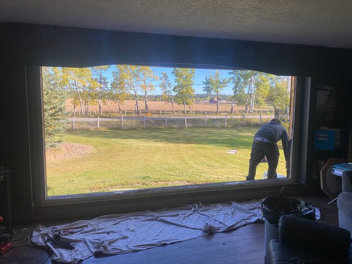 Installer fitting the oversize picture window, seen from inside
